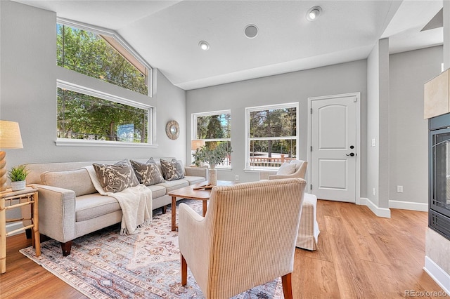 living area featuring light wood finished floors, vaulted ceiling, baseboards, and recessed lighting