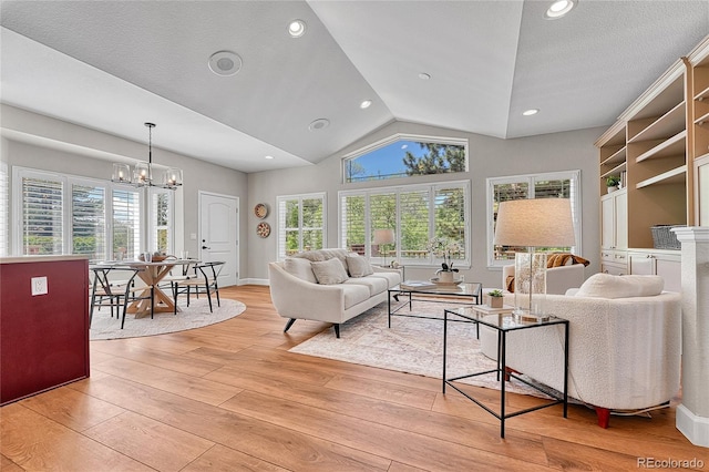 living area featuring light wood finished floors, a chandelier, lofted ceiling, and recessed lighting