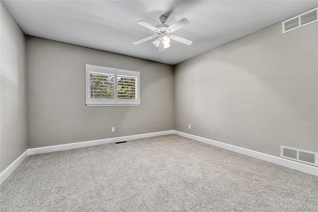 carpeted spare room with ceiling fan, baseboards, and a textured ceiling