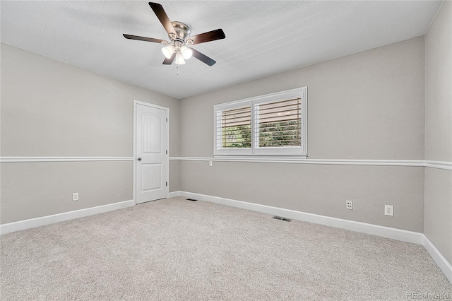 carpeted spare room featuring ceiling fan and baseboards
