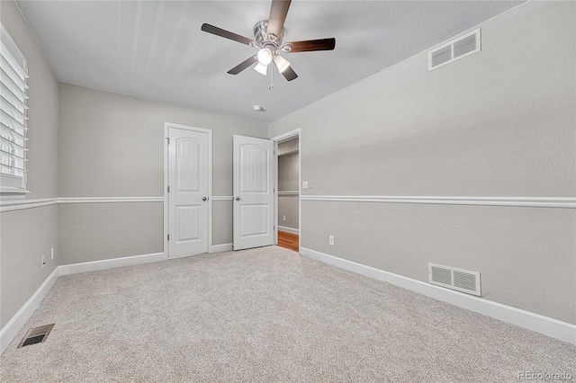 unfurnished bedroom with carpet, baseboards, a ceiling fan, and a closet
