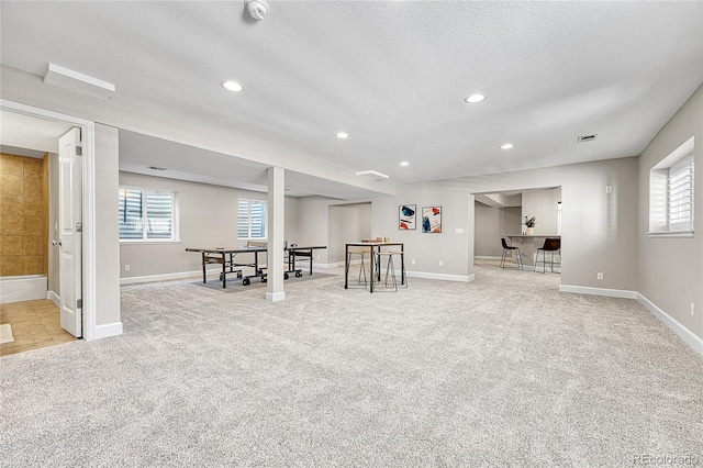 basement featuring carpet floors, a textured ceiling, healthy amount of natural light, baseboards, and recessed lighting