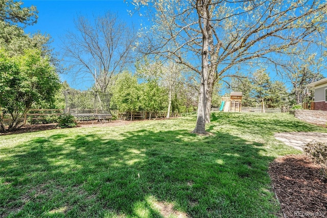 view of yard with a trampoline and a playground