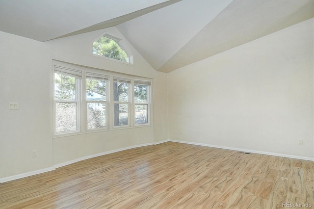 spare room featuring high vaulted ceiling and light hardwood / wood-style floors