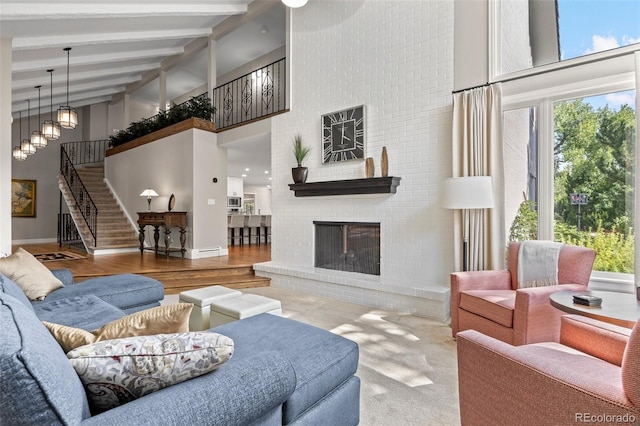 living room with beam ceiling, hardwood / wood-style floors, a brick fireplace, and high vaulted ceiling