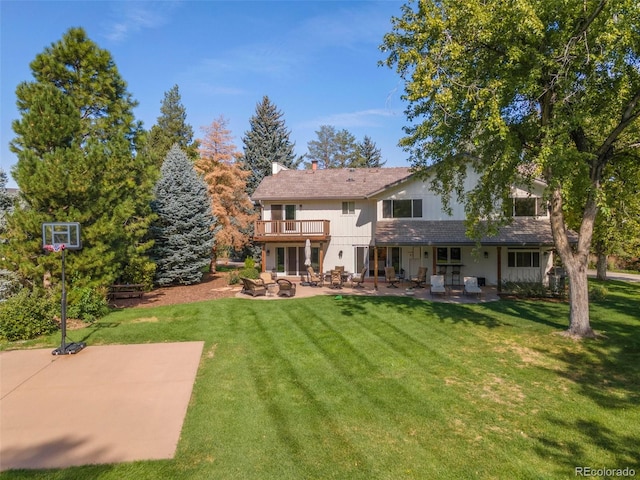 back of property with a patio area, a lawn, and a balcony