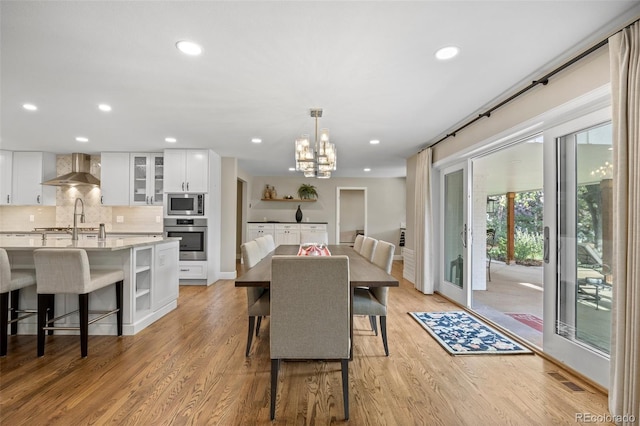 dining space with a notable chandelier and light wood-type flooring