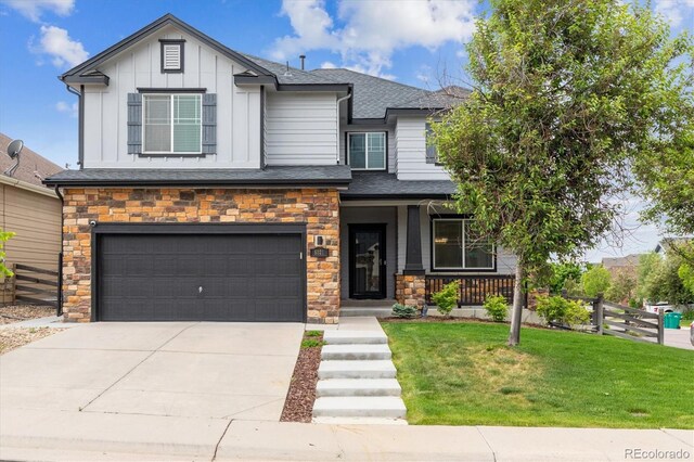 5021 S Rome St, Aurora, CO 80015 - view of front of home with a porch, an attached garage, stone siding, concrete driveway, and board and batten siding