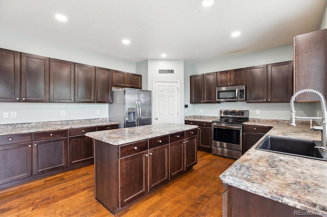 5021 S Rome St, Aurora, CO 80015 - kitchen with stainless steel appliances, a sink, a center island, dark wood-type flooring, and dark brown cabinets