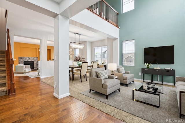 5021 S Rome St, Aurora, CO 80015 - living room featuring stairs, hardwood / wood-style flooring, baseboards, a fireplace, and a chandelier