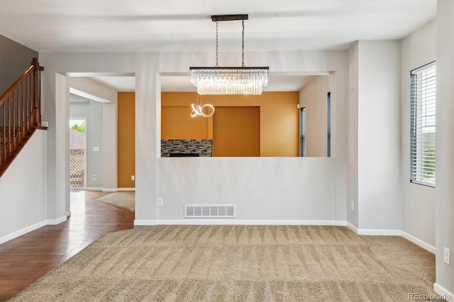 5021 S Rome St, Aurora, CO 80015 - spare room with a chandelier, healthy amount of natural light, wood finished floors, and baseboards