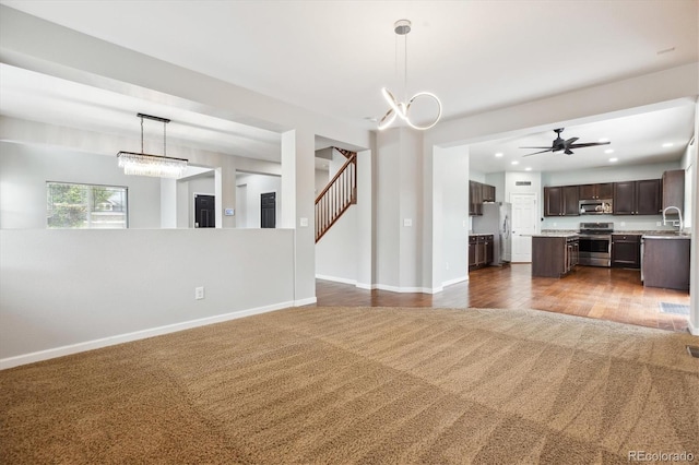 5021 S Rome St, Aurora, CO 80015 - unfurnished living room with dark carpet, baseboards, recessed lighting, a ceiling fan, and stairs