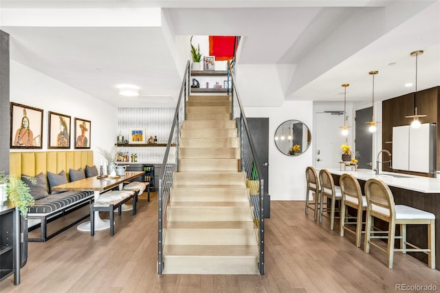 stairway with hardwood / wood-style flooring and sink