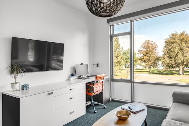 carpeted office space featuring a healthy amount of sunlight and built in desk