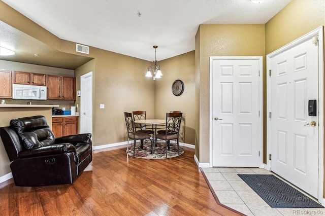 entrance foyer with light hardwood / wood-style floors and a chandelier