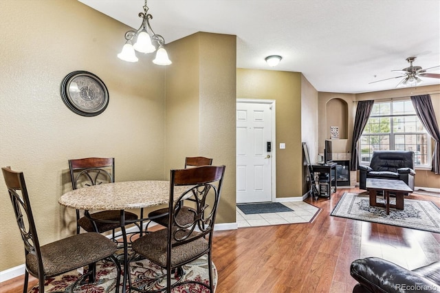 dining room featuring light wood-type flooring and ceiling fan with notable chandelier