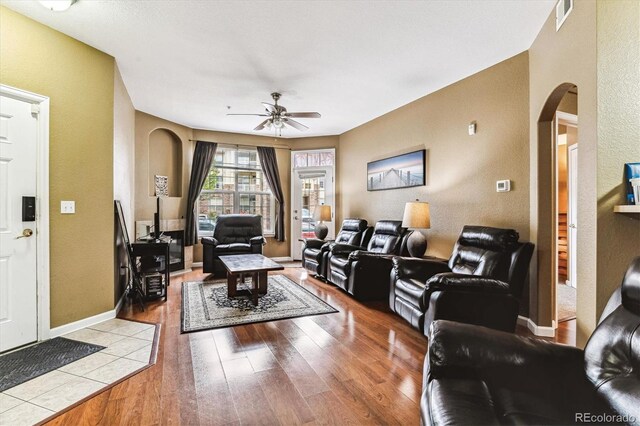 living room with ceiling fan and light hardwood / wood-style flooring