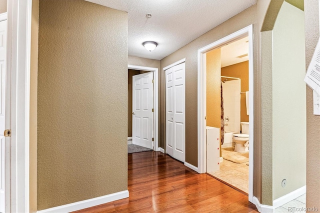 hall featuring hardwood / wood-style floors and a textured ceiling