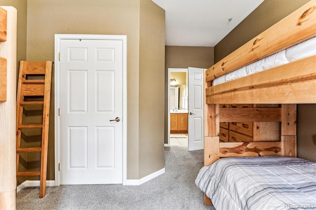 bedroom with connected bathroom and carpet flooring