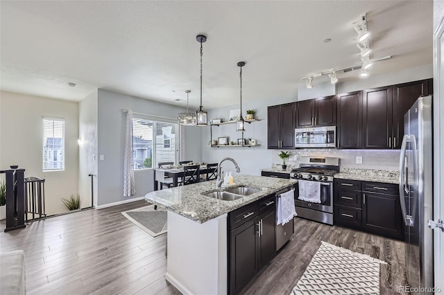 12910 Grant Cir W Unit C, Thornton, CO 80241 - kitchen with appliances with stainless steel finishes, dark wood-style floors, tasteful backsplash, hanging light fixtures, and an island with sink