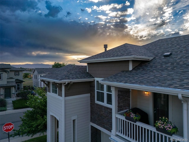 12910 Grant Cir W Unit C, Thornton, CO 80241 - property exterior at dusk featuring roof with shingles and stone siding