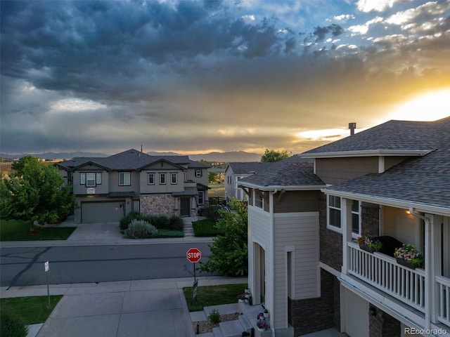 12910 Grant Cir W Unit C, Thornton, CO 80241 - exterior space featuring a shingled roof, concrete driveway, and stone siding