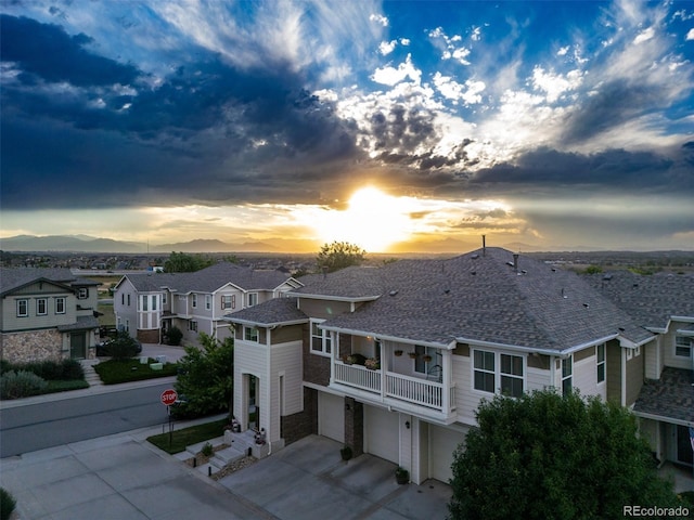12910 Grant Cir W Unit C, Thornton, CO 80241 - view of front facade with a garage, concrete driveway, a residential view, roof with shingles, and a balcony