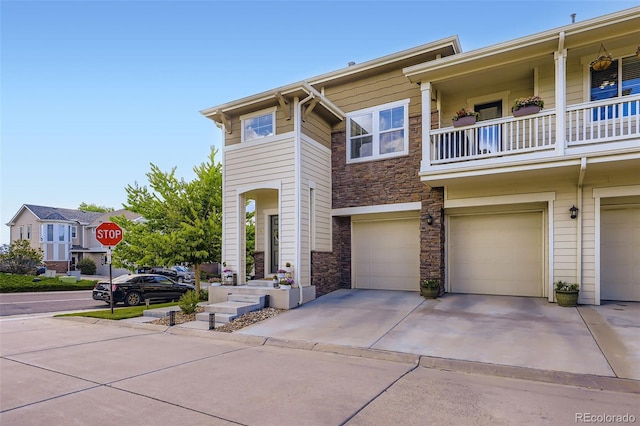 12910 Grant Cir W Unit C, Thornton, CO 80241 - view of front of home featuring stone siding, an attached garage, and driveway