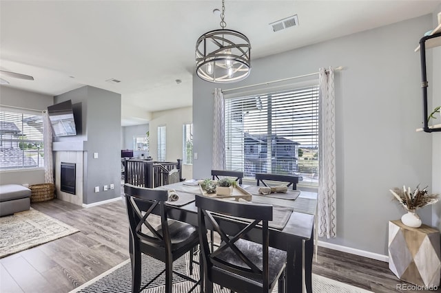 12910 Grant Cir W Unit C, Thornton, CO 80241 - dining area featuring wood finished floors, a tiled fireplace, and a chandelier