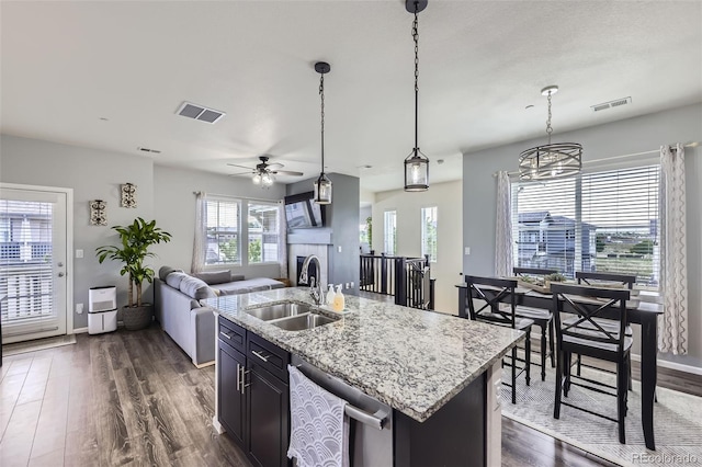 12910 Grant Cir W Unit C, Thornton, CO 80241 - kitchen with dishwasher, dark wood finished floors, open floor plan, a ceiling fan, and a fireplace