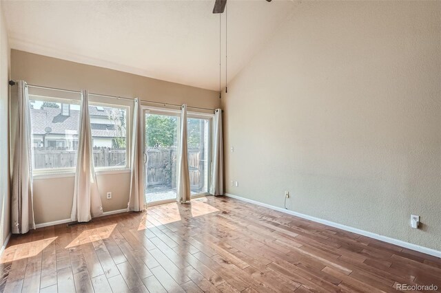 empty room with light hardwood / wood-style floors and lofted ceiling