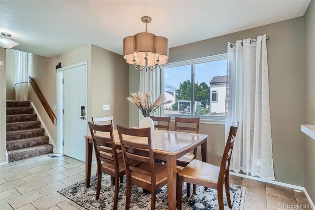 dining area with light tile patterned flooring and a chandelier