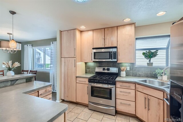 kitchen featuring appliances with stainless steel finishes, light brown cabinets, and a wealth of natural light