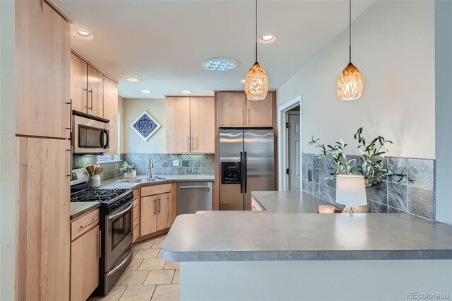 kitchen featuring appliances with stainless steel finishes, hanging light fixtures, decorative backsplash, light brown cabinetry, and sink