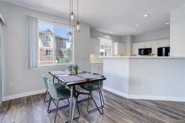 dining area featuring plenty of natural light and dark hardwood / wood-style flooring