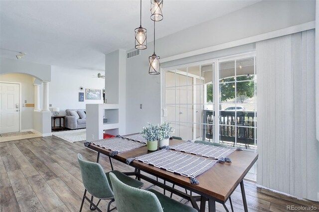 dining area featuring ceiling fan, hardwood / wood-style floors, and ornate columns