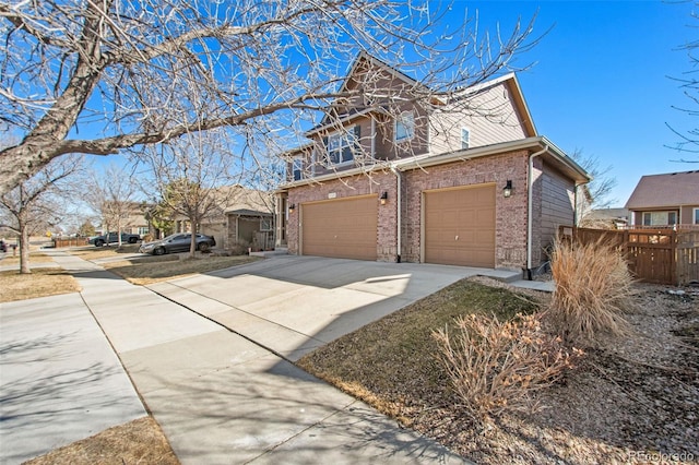 view of front facade featuring driveway, an attached garage, and brick siding