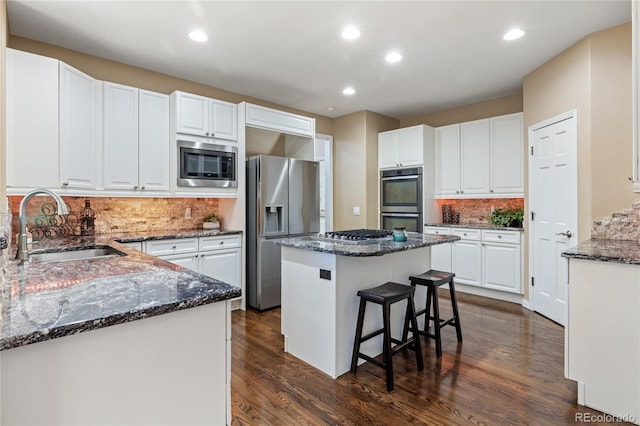 6405 Eagle Feather Trl, Littleton, CO 80125 - kitchen featuring appliances with stainless steel finishes, a sink, dark stone counters, and recessed lighting