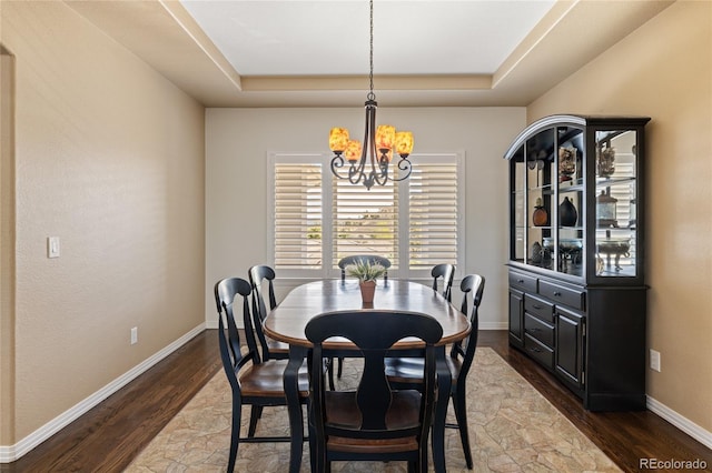6405 Eagle Feather Trl, Littleton, CO 80125 - dining space with a chandelier, a tray ceiling, baseboards, and dark wood-style floors