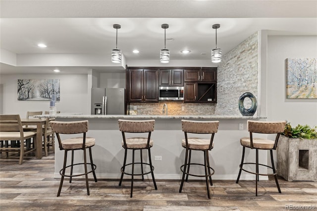 6405 Eagle Feather Trl, Littleton, CO 80125 - kitchen featuring stainless steel appliances, dark brown cabinets, wood finished floors, recessed lighting, and backsplash