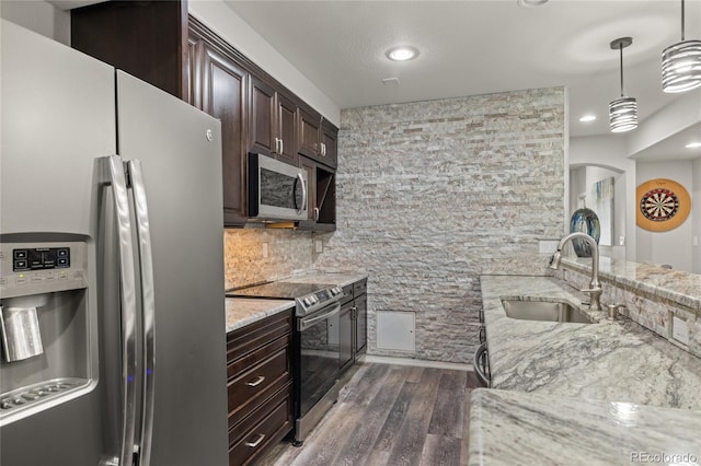 6405 Eagle Feather Trl, Littleton, CO 80125 - kitchen featuring stainless steel appliances, a sink, dark wood-style floors, light stone counters, and dark brown cabinets