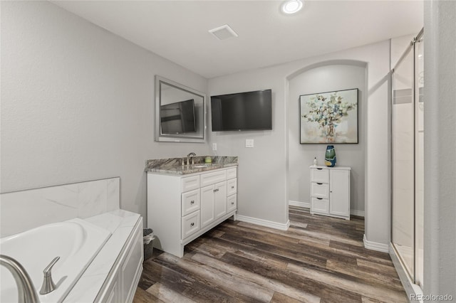 6405 Eagle Feather Trl, Littleton, CO 80125 - bathroom with a stall shower, vanity, wood finished floors, a bath, and recessed lighting