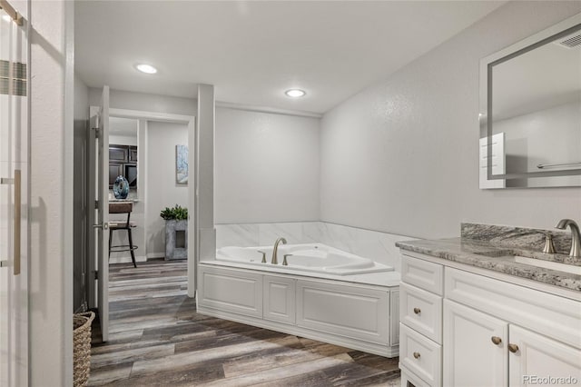 6405 Eagle Feather Trl, Littleton, CO 80125 - bathroom featuring wood finished floors, vanity, a bath, and recessed lighting