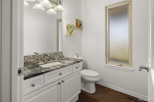 6405 Eagle Feather Trl, Littleton, CO 80125 - half bathroom with vanity, toilet, wood finished floors, and baseboards