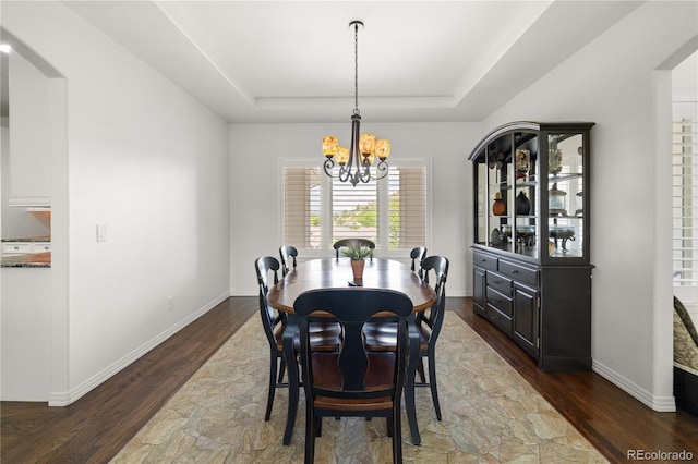 6405 Eagle Feather Trl, Littleton, CO 80125 - dining room with a raised ceiling, a chandelier, stone finish flooring, baseboards, and arched walkways