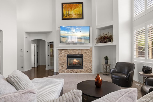 6405 Eagle Feather Trl, Littleton, CO 80125 - living area with a towering ceiling, a glass covered fireplace, baseboards, and carpet flooring