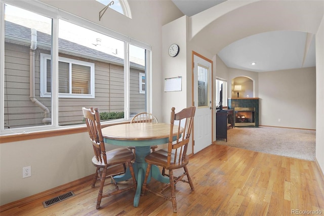 dining room featuring a fireplace and light hardwood / wood-style flooring