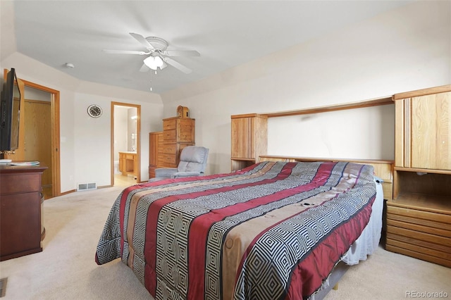 carpeted bedroom with ensuite bathroom and ceiling fan