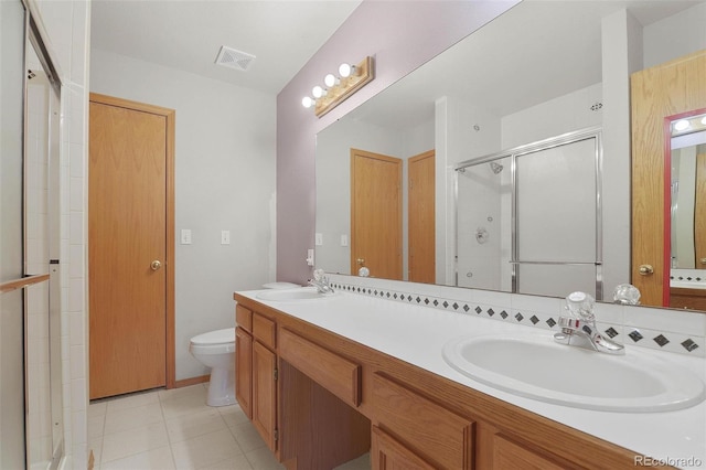 bathroom with vanity, a shower with shower door, and toilet