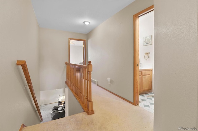 hallway featuring light colored carpet